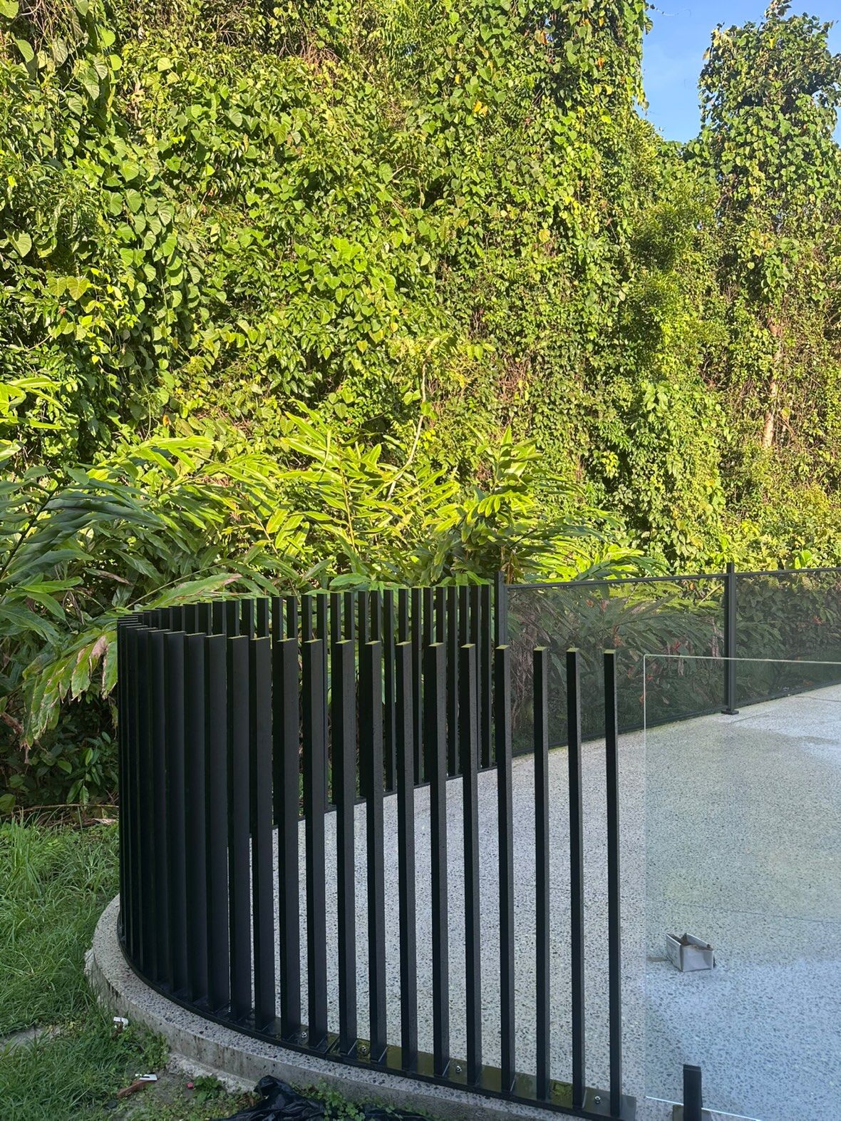 A matte black aluminium fence formed to a curve