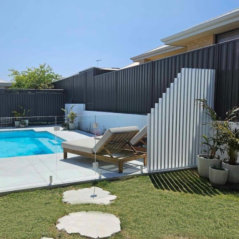 A white aluminium fence raked to follow a sloping boundary