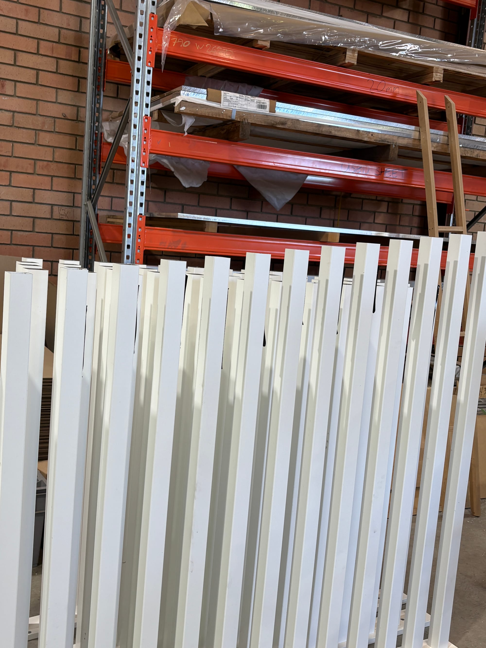 Finished aluminium sections stacked on pallet racking in the Landsdale factory